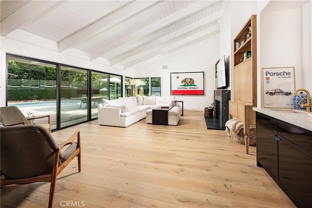 living room featuring beam ceiling, light wood-type flooring, and high vaulted ceiling