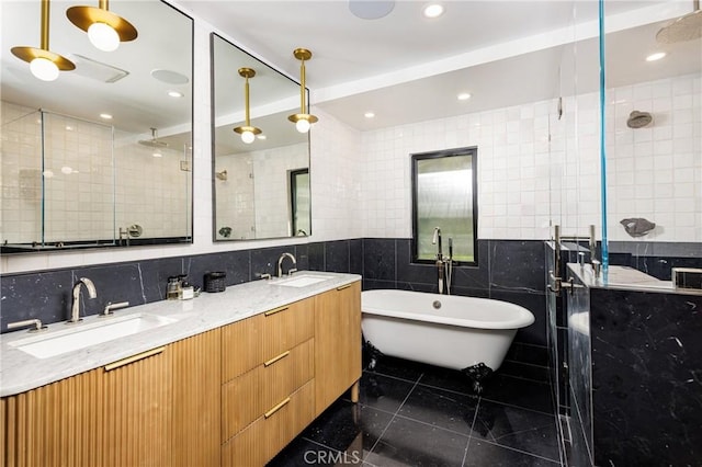 full bath featuring double vanity, a freestanding tub, a sink, a shower stall, and tile walls