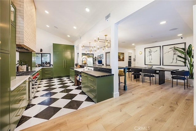 kitchen featuring stainless steel appliances, light floors, visible vents, and green cabinets