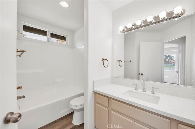 full bath with vanity, toilet, wood finished floors, and shower / bathtub combination