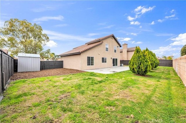 rear view of property featuring stucco siding, a patio, a fenced backyard, a yard, and an outdoor structure