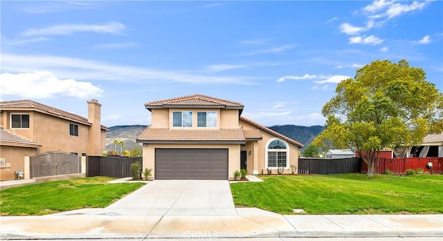 mediterranean / spanish home featuring a mountain view, a tile roof, a front lawn, and fence