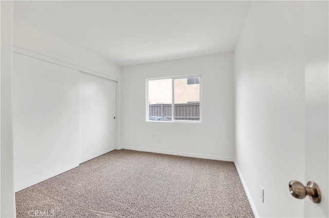 carpeted empty room with baseboards