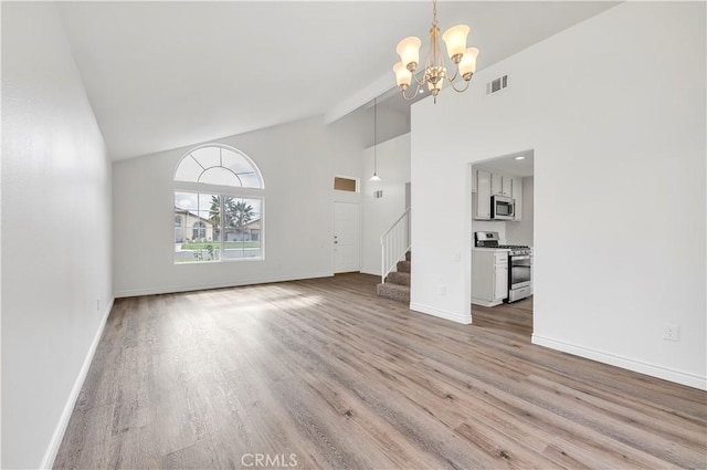 unfurnished living room with stairway, wood finished floors, baseboards, visible vents, and a chandelier