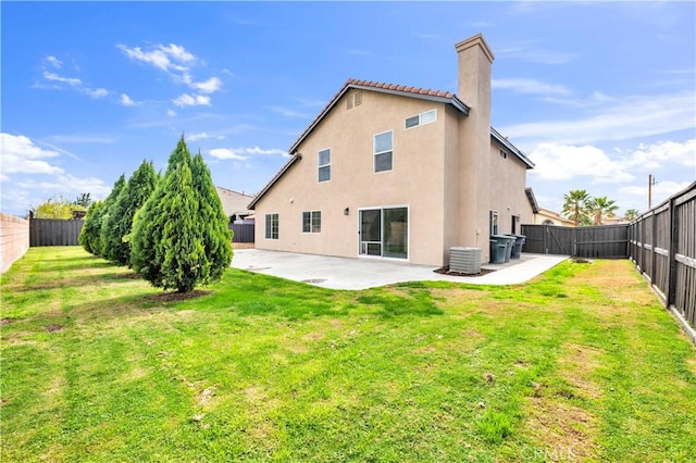 rear view of house with stucco siding, a patio, a fenced backyard, a yard, and central AC unit