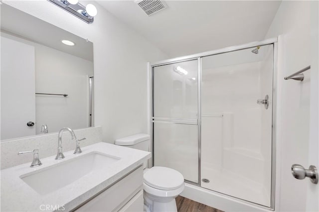 full bathroom featuring visible vents, a shower stall, toilet, and vanity