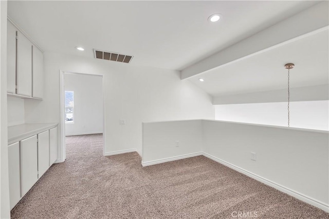 empty room featuring visible vents, vaulted ceiling with beams, baseboards, light carpet, and recessed lighting