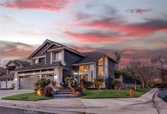 view of front of property with concrete driveway, a tiled roof, a garage, and a front lawn