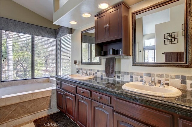 full bathroom featuring a wealth of natural light, a garden tub, and a sink