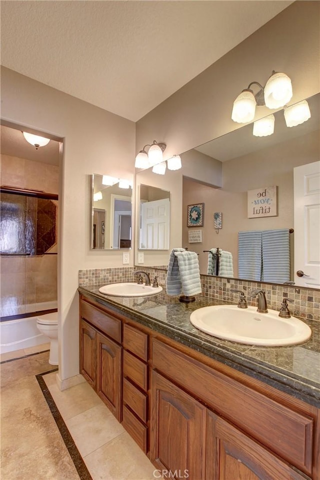 bathroom featuring tasteful backsplash, toilet, and a sink