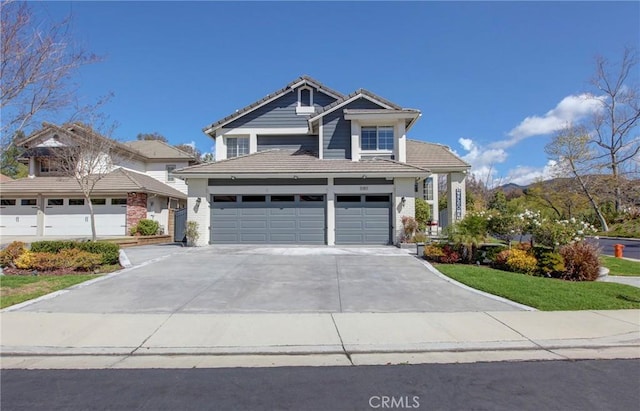 craftsman house with a tiled roof, an attached garage, and driveway