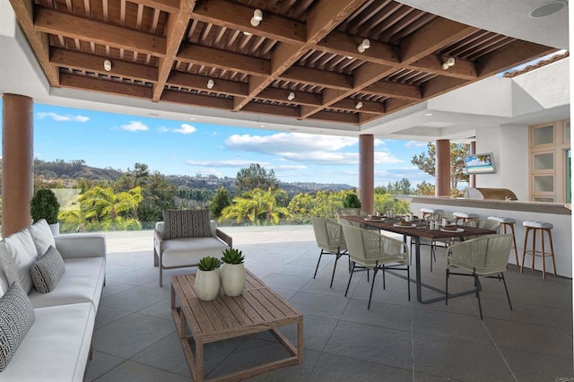 view of patio / terrace featuring outdoor wet bar, an outdoor hangout area, outdoor dining space, and exterior kitchen