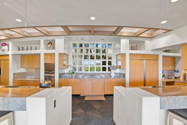 kitchen with beamed ceiling, stone finish flooring, coffered ceiling, recessed lighting, and paneled built in fridge