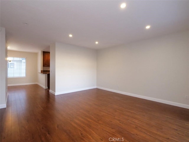 spare room with dark wood finished floors, recessed lighting, and baseboards