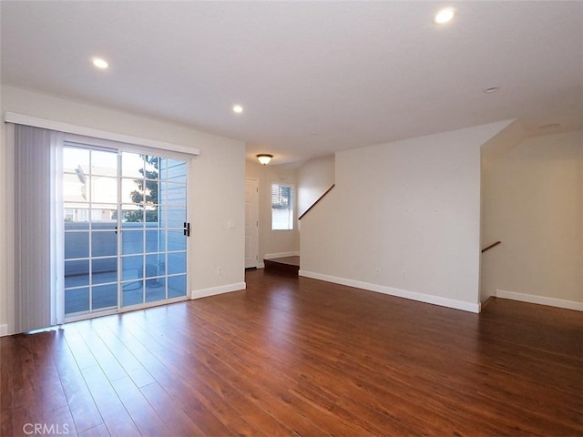 unfurnished living room with stairway, recessed lighting, baseboards, and wood finished floors