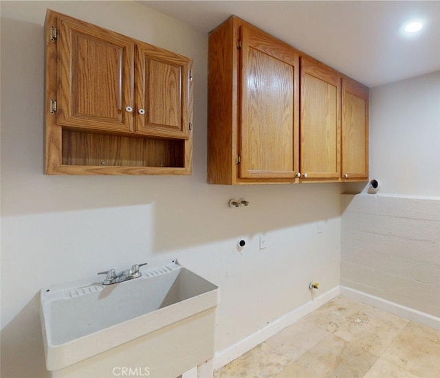 laundry room featuring baseboards, gas dryer hookup, washer hookup, cabinet space, and a sink