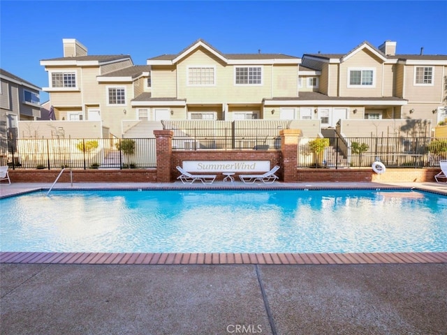 community pool with fence and a residential view