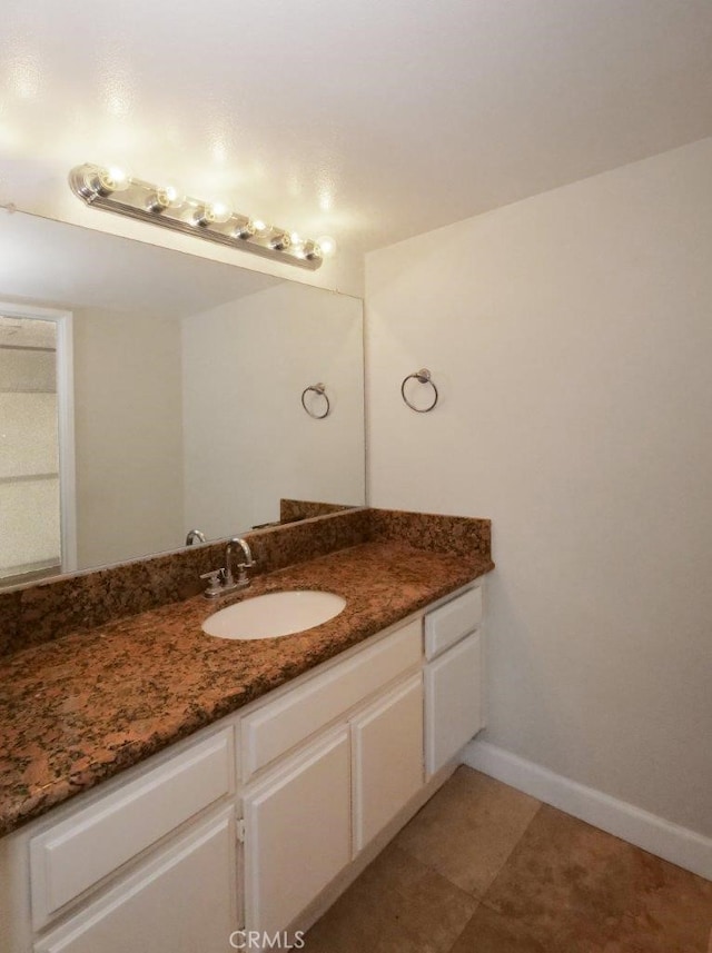 bathroom featuring baseboards, vanity, and tile patterned flooring