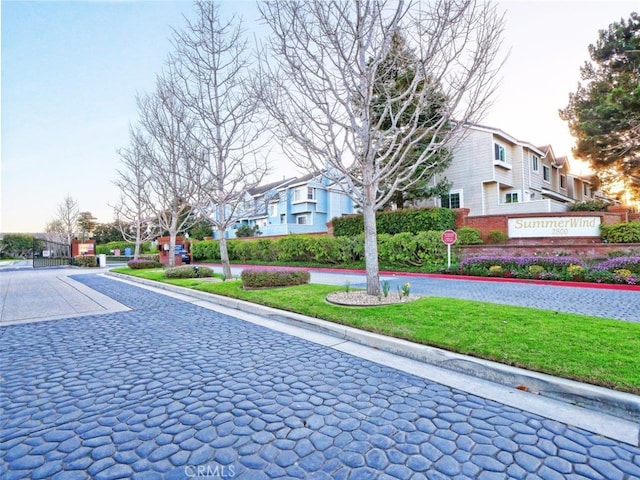 view of road with curbs, a residential view, and a gated entry