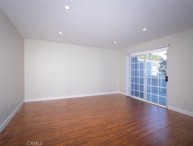 spare room featuring recessed lighting, wood finished floors, and baseboards