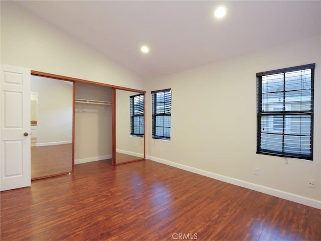 unfurnished bedroom featuring wood finished floors, recessed lighting, a closet, baseboards, and vaulted ceiling