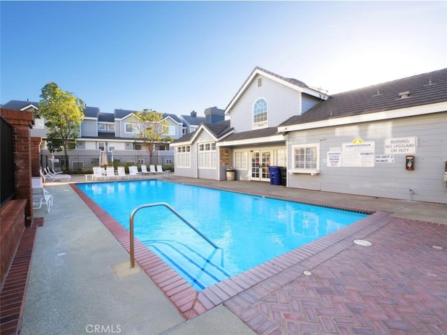 pool featuring french doors, a patio, and fence