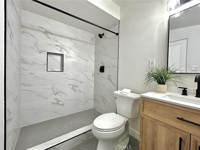 full bathroom with a marble finish shower, toilet, and vanity