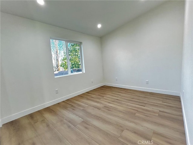 spare room featuring recessed lighting, baseboards, and light wood-style floors