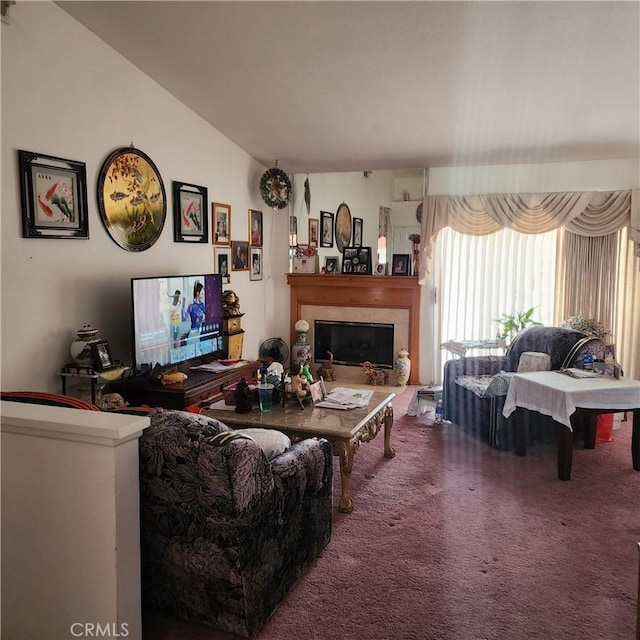 living area with carpet floors, a glass covered fireplace, and vaulted ceiling