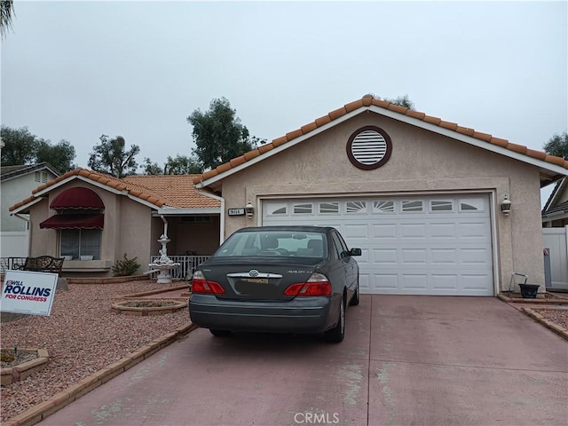 view of front of house featuring stucco siding, an attached garage, driveway, and a tile roof