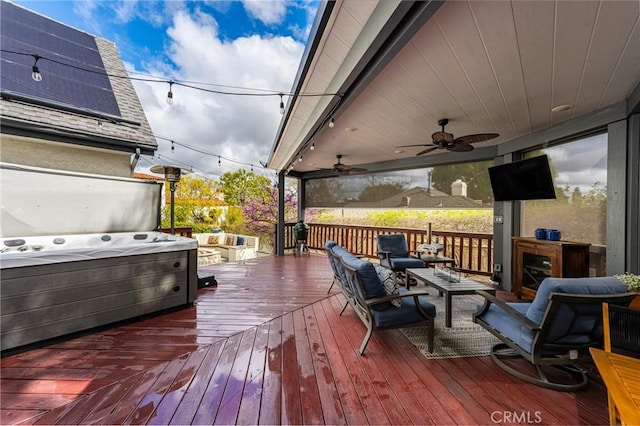 deck with a ceiling fan and a hot tub