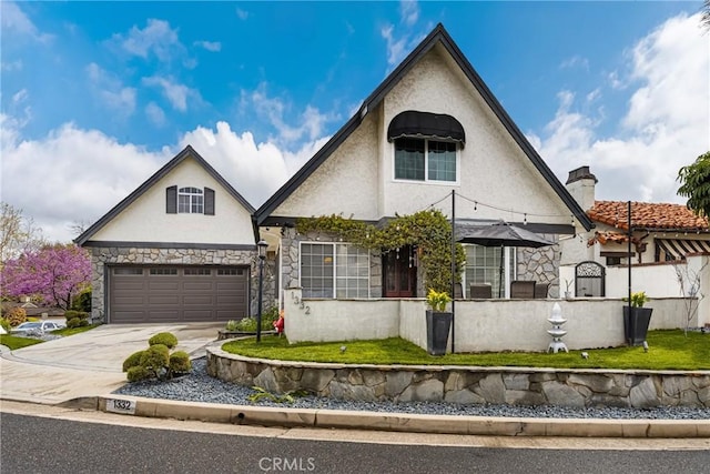 view of front facade featuring stucco siding, stone siding, an attached garage, and driveway