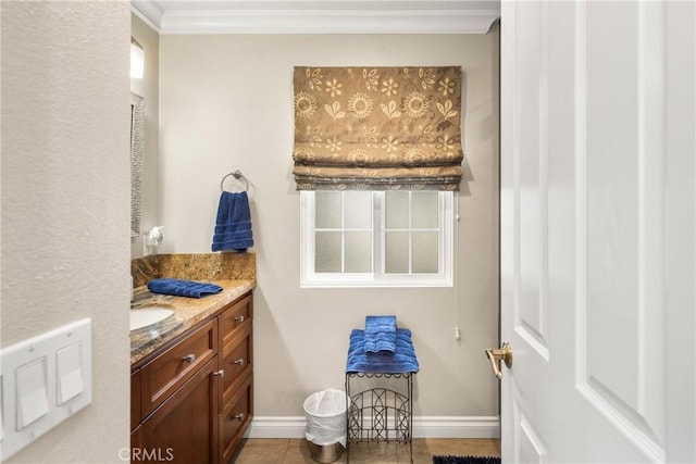 bathroom featuring baseboards, plenty of natural light, vanity, and crown molding