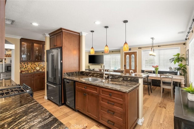 kitchen with ornamental molding, black appliances, light wood-type flooring, and a sink