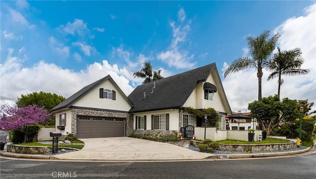 view of front of property featuring stone siding, stucco siding, and concrete driveway