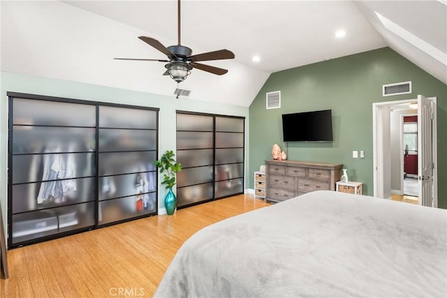 bedroom featuring visible vents, vaulted ceiling with skylight, and wood finished floors