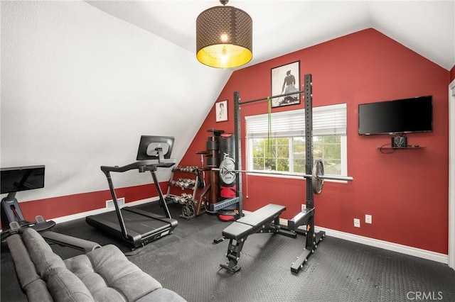 exercise area featuring vaulted ceiling and baseboards