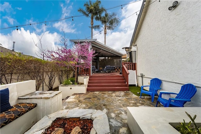 view of patio with a wooden deck and fence