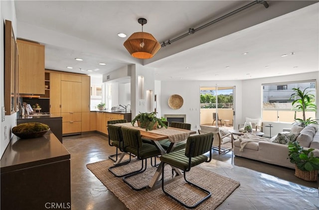 dining area with recessed lighting, finished concrete flooring, and a fireplace