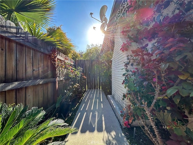 view of side of home featuring fence and brick siding