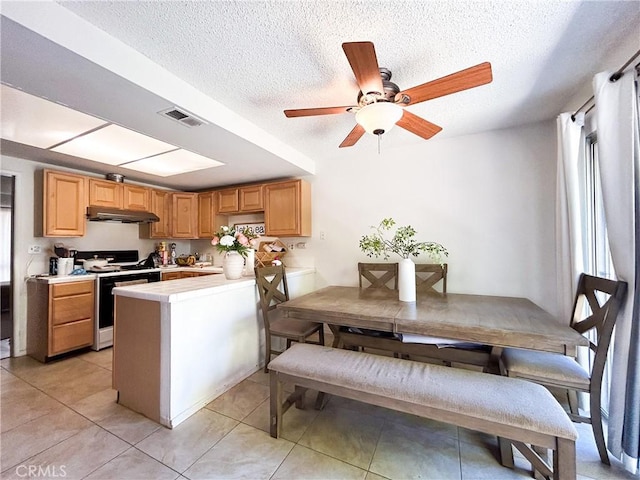 kitchen with visible vents, under cabinet range hood, a peninsula, light countertops, and white range with gas stovetop