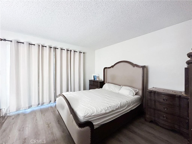 bedroom featuring a textured ceiling and wood finished floors