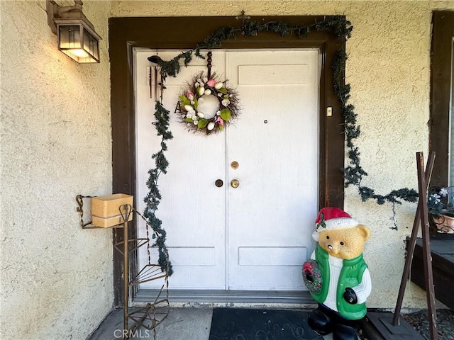 doorway to property featuring stucco siding