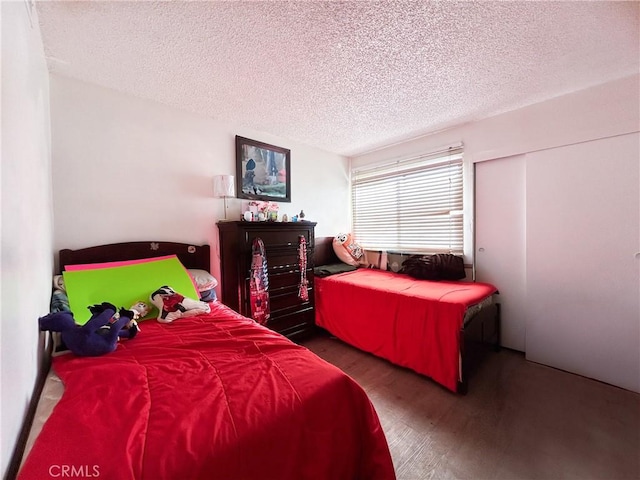 bedroom featuring wood finished floors and a textured ceiling