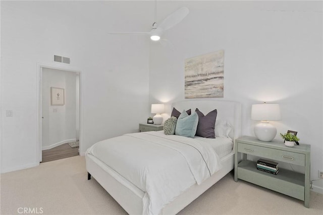 bedroom with a ceiling fan, baseboards, visible vents, carpet floors, and a high ceiling