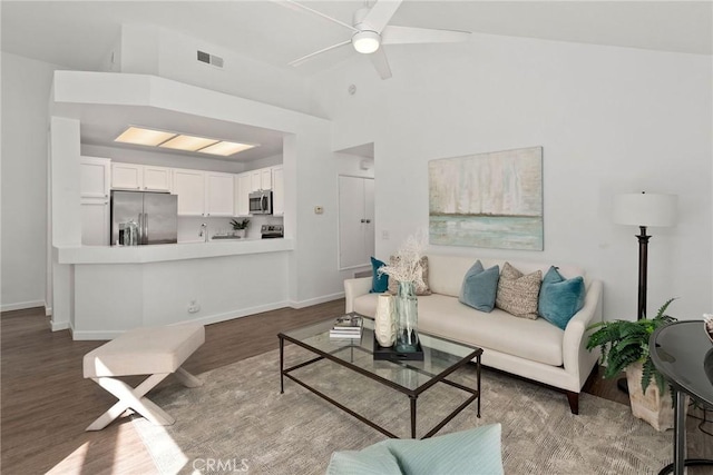 living room with ceiling fan, wood finished floors, visible vents, and baseboards