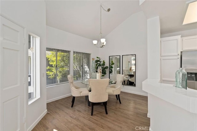 dining space with wood finished floors, baseboards, and a chandelier