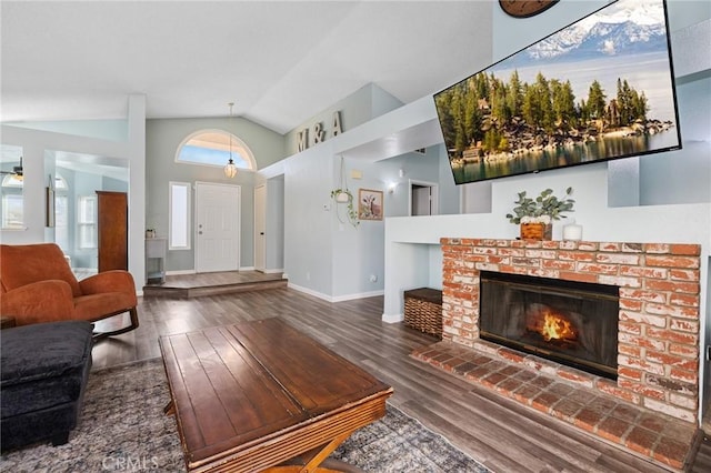 living room with a fireplace, high vaulted ceiling, baseboards, and wood finished floors