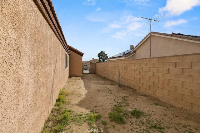 view of side of home with fence and stucco siding