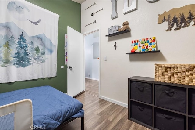 bedroom featuring baseboards and wood finished floors